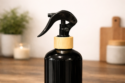 Black spray bottle with wooden nozzle on a wooden surface