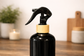 Black spray bottle with wooden nozzle on a wooden surface