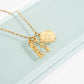 Gold necklace with 'blessed' pendant on a light green background