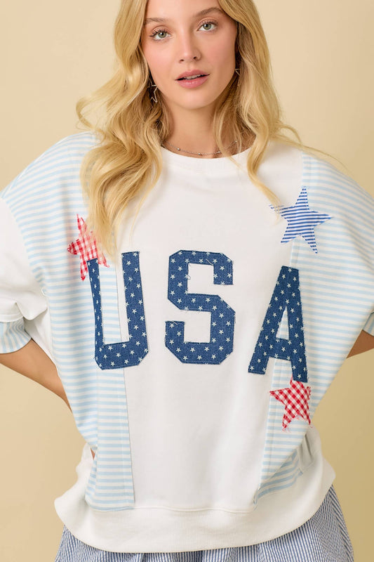 Woman wearing a white t-shirt with 'USA' and star designs on a beige background