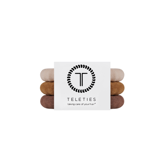 Stack of hair ties with a Teleties branded card on a white background