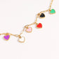 Gold chain necklace with colorful heart-shaped pendants on a white background