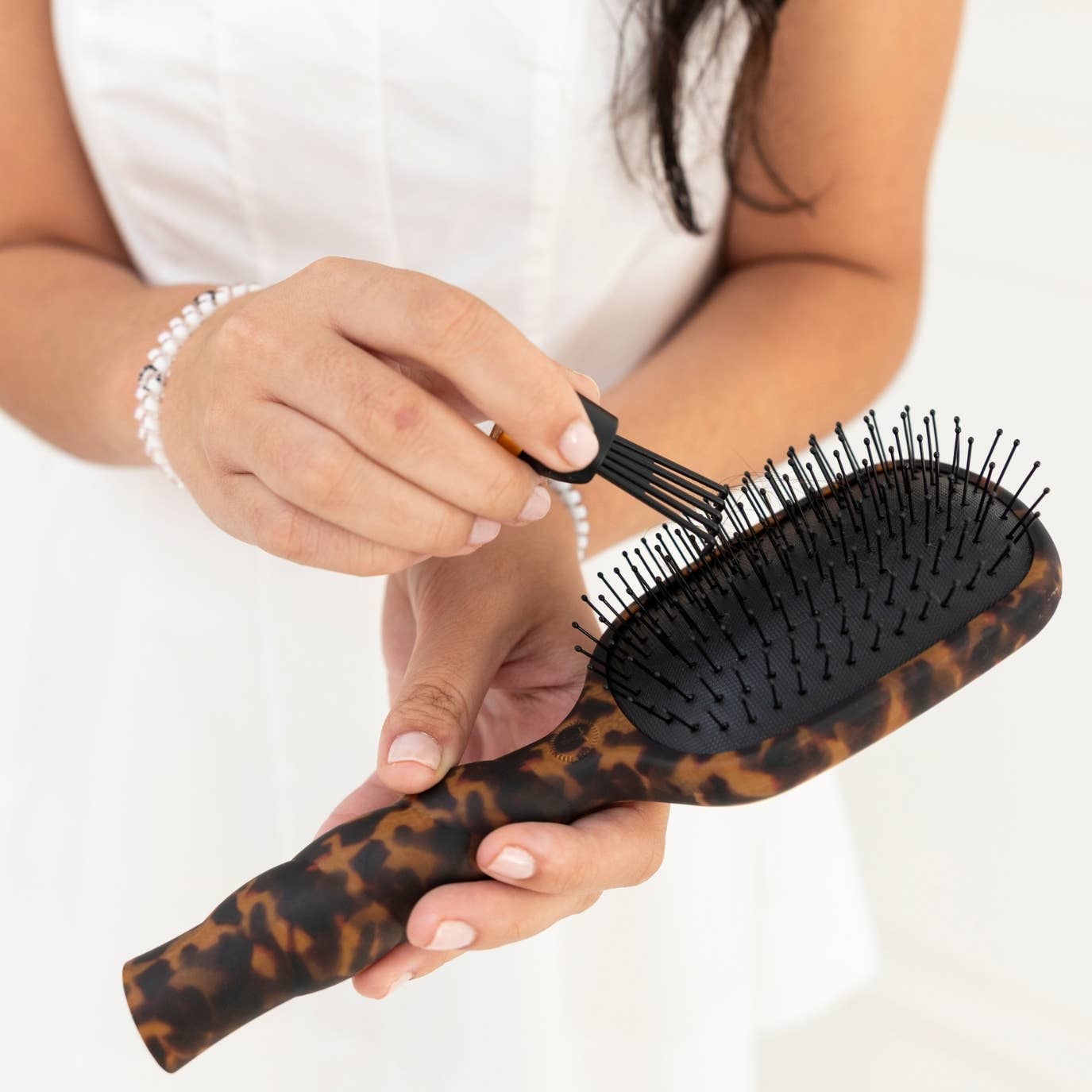 Teleties comb cleaner with medium hair brush on a white background