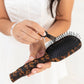 Teleties comb cleaner with medium hair brush on a white background