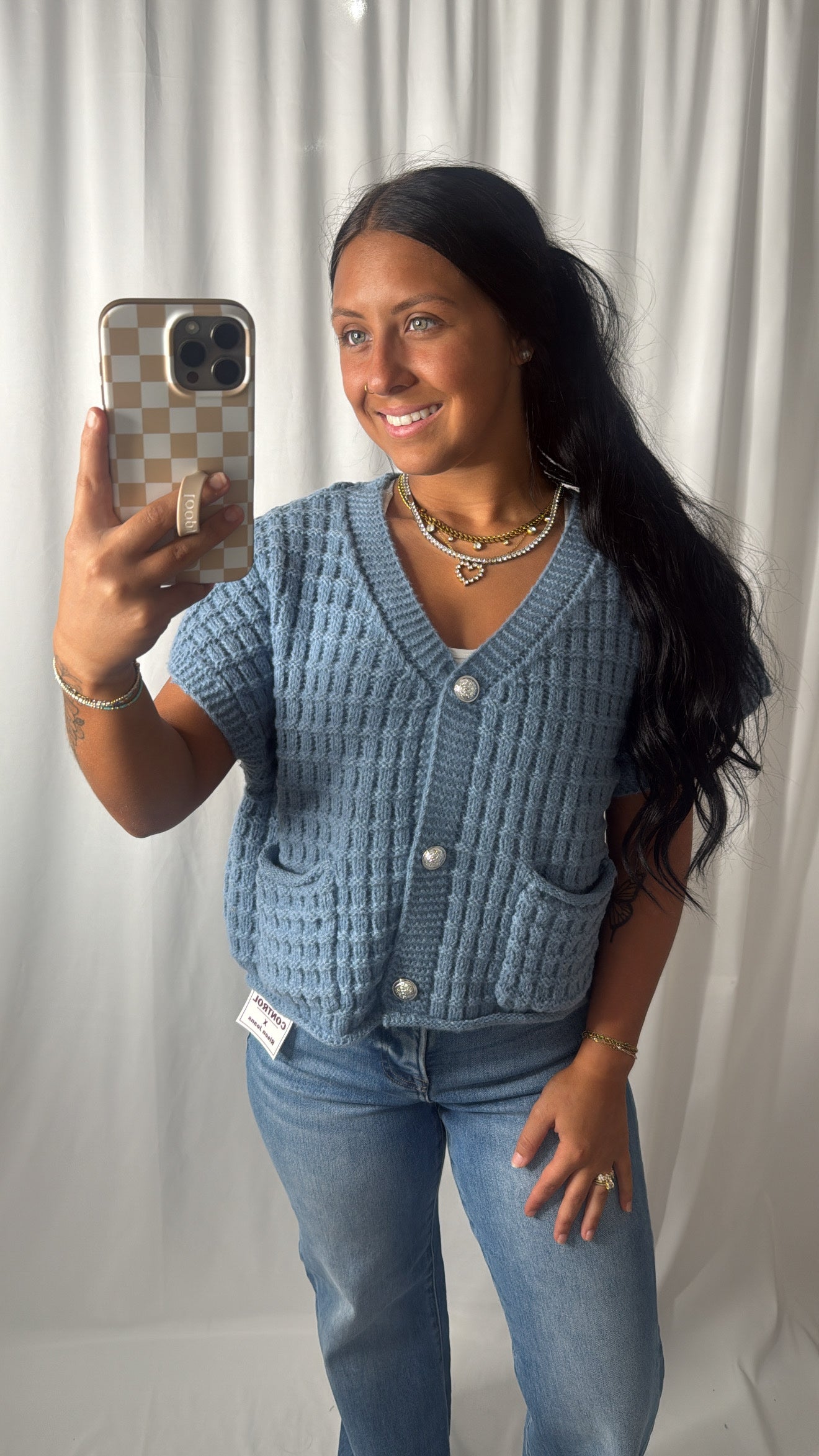 A women wearing a blue cardigan with buttons on a white background