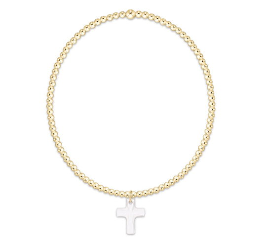 Gold beaded bracelet with a clear cross charm on a white background