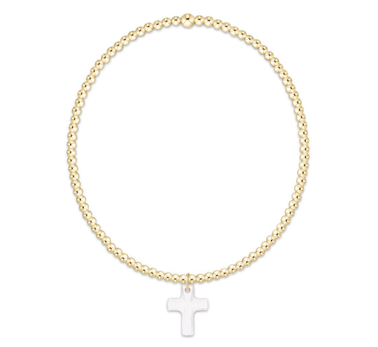 Gold beaded bracelet with a clear cross charm on a white background