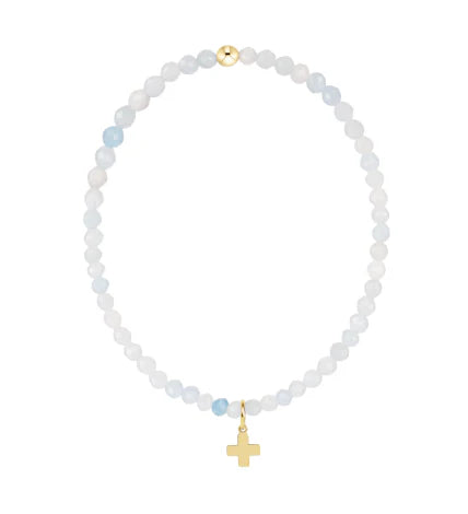 Beaded white and aqua blue bracelet with gold cross charm on a white background