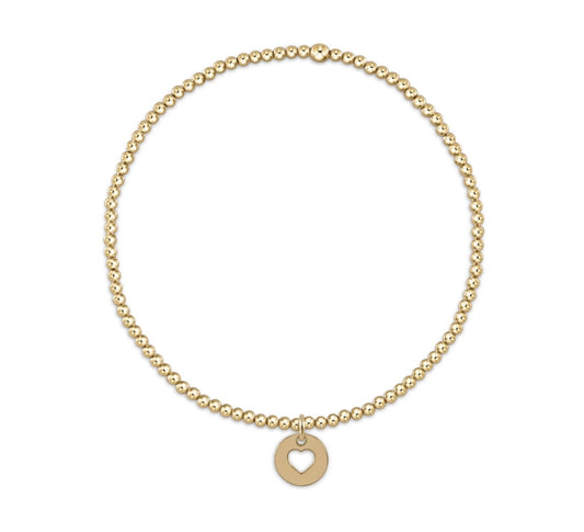 Gold beaded enewton bracelet with gold heart charm on a white background