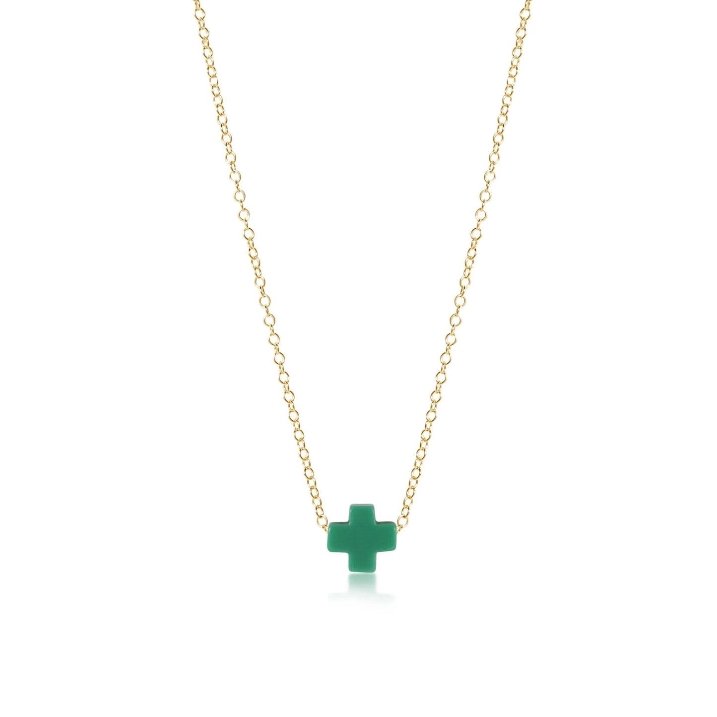 A gold enewton necklace with a green cross pendant on a white background.