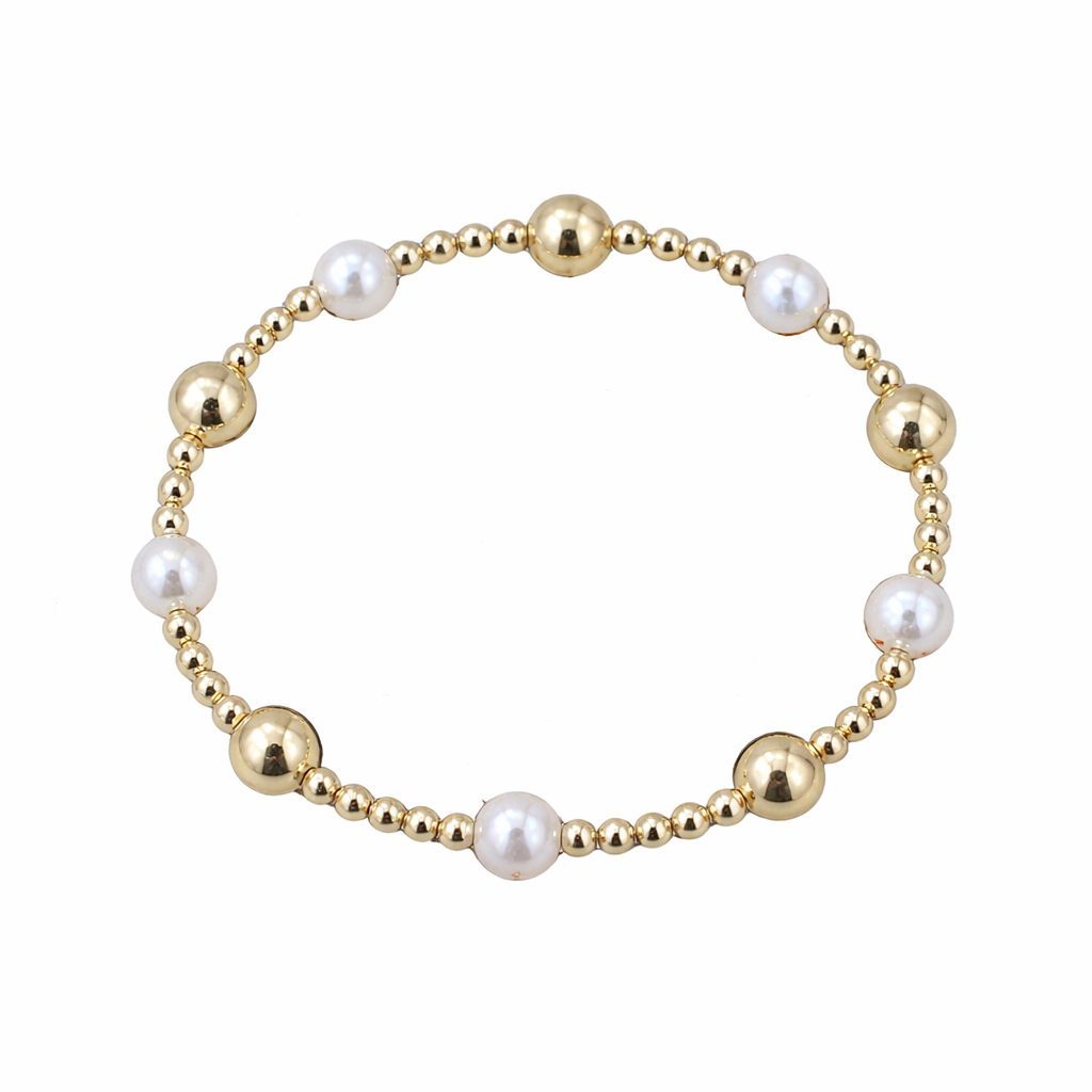 Bracelet with gold beads and pearls on a white background branded by Enewton