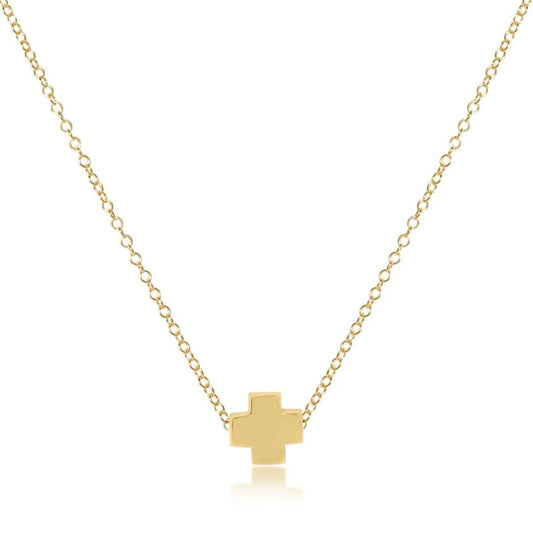 A gold-filled cross necklace on a gold-filled chain, branded by enewton presented against a white background.
