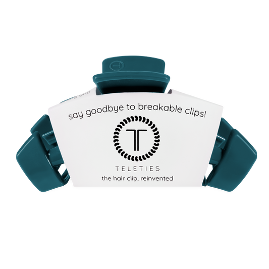 A single teal hair clip with a white paper insert that reads 'say goodbye to breakable clips! TELETIES the hair clip, reinvented' on a plain white background.