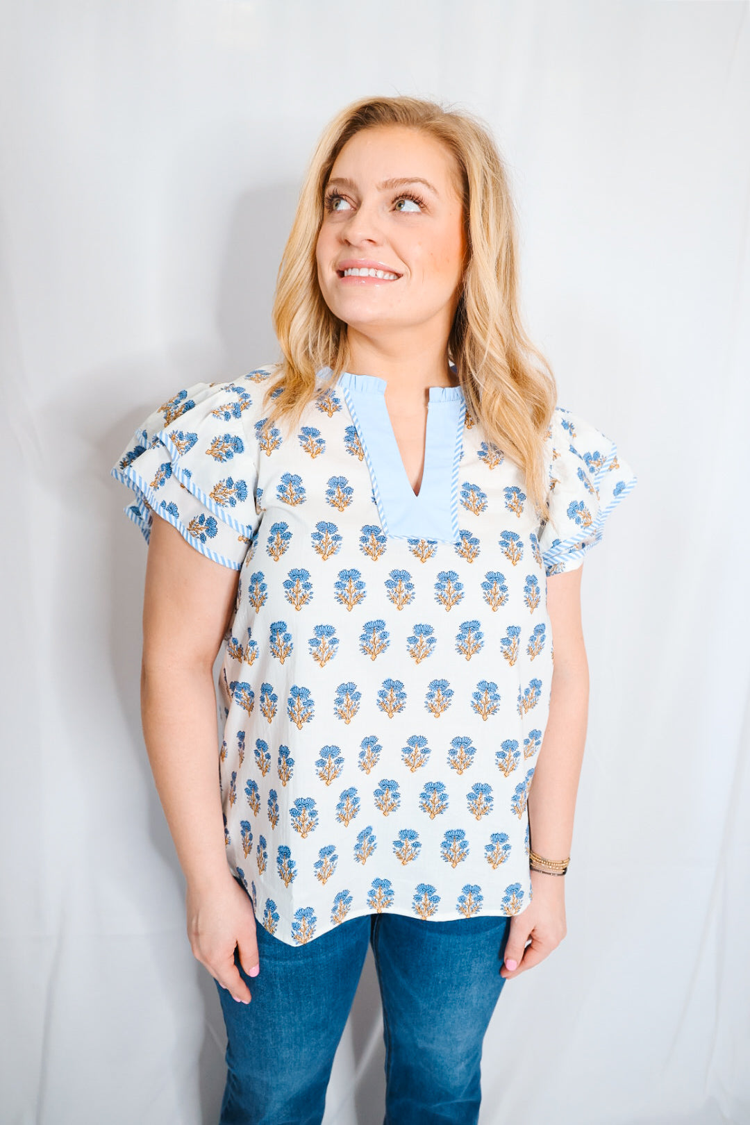 Woman wearing a floral blouse with a plain background