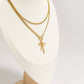 Gold necklace with a bow pendant on a white mannequin.