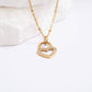 Gold heart-shaped necklace with embedded stones on a white background