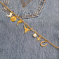Gold paperclip chain with charms on a denim background