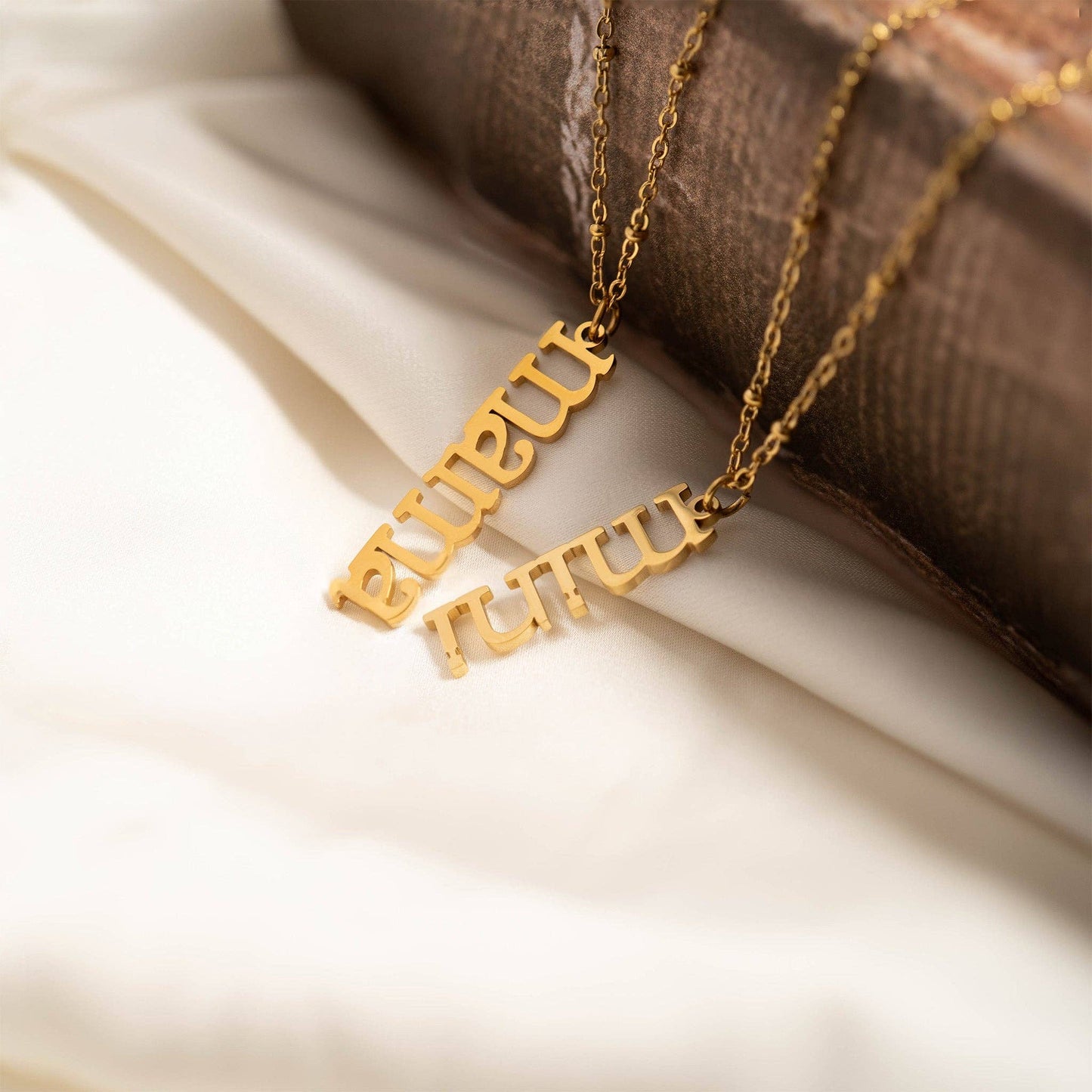 Gold necklace with pendant on a soft fabric background