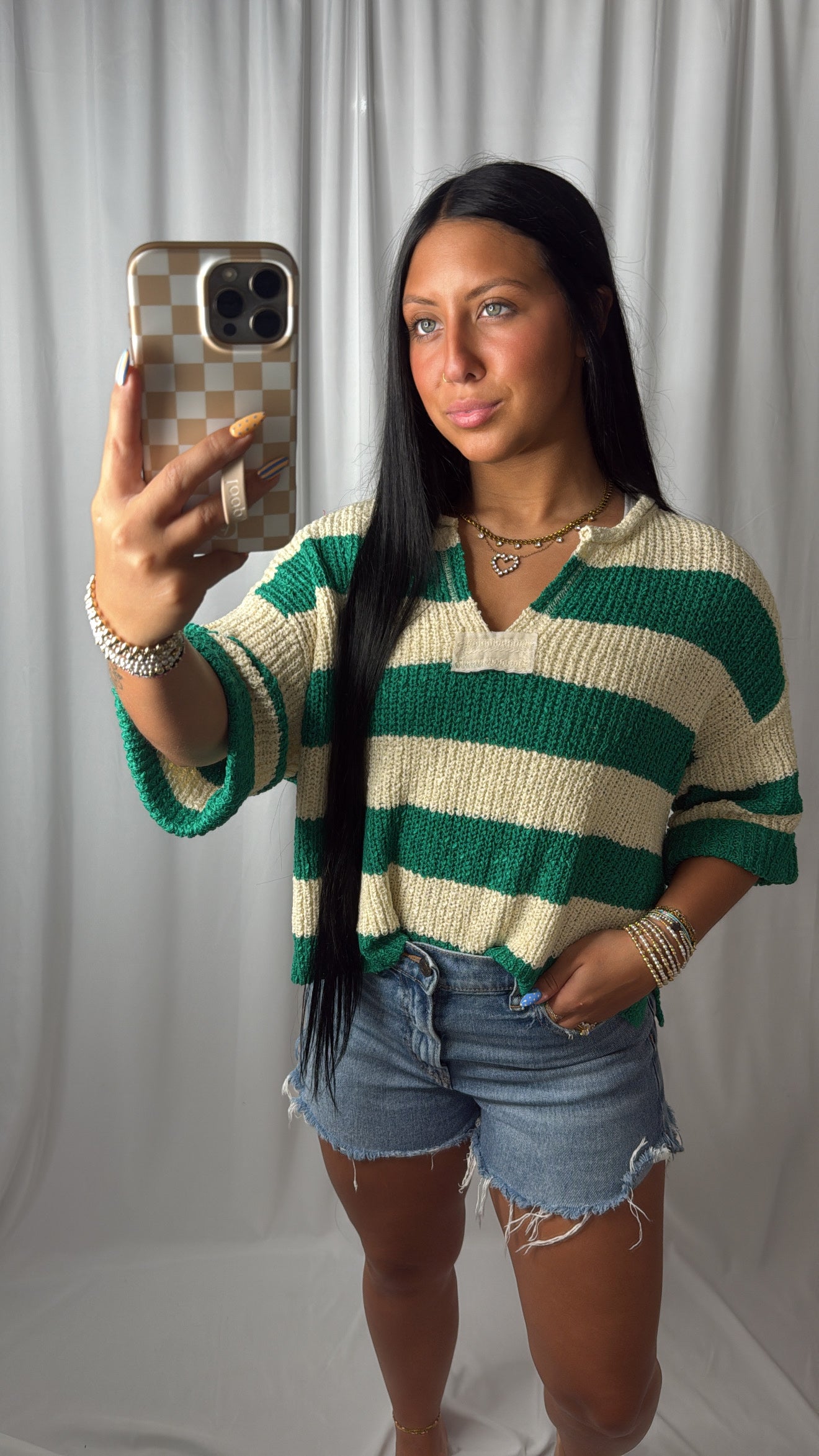 Woman wearing a green and cream stripped knit sweater top