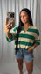 Woman wearing a green and cream stripped knit sweater top