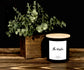 Candle labeled 'The Westin' with a plant on a wooden surface