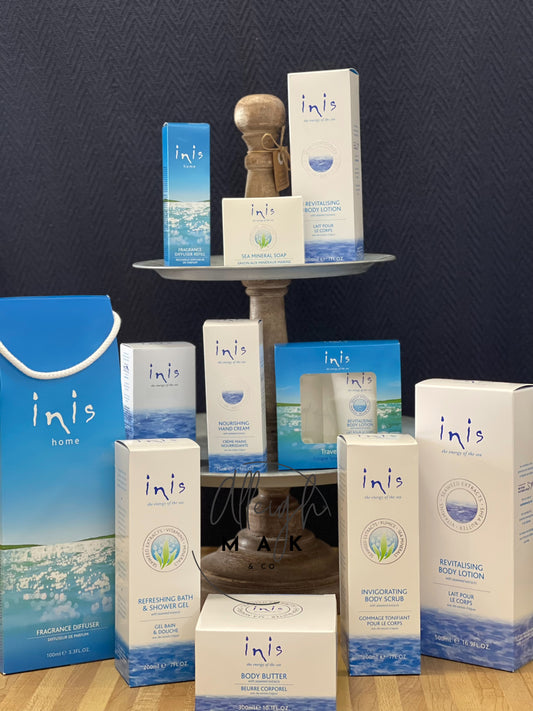 Collection of Inis skincare and home products on a dark background