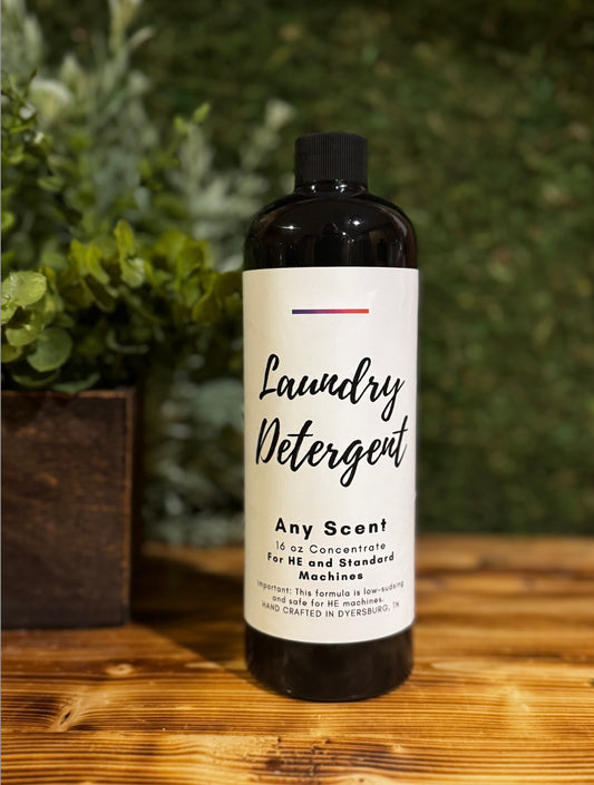 Bottle of laundry detergent on a wooden surface with greenery in the background