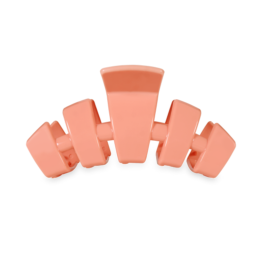 Coral-colored hair clip on a white background