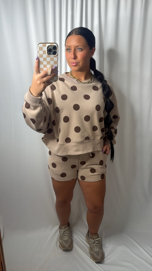A women wearing a brown mocha color two piece polka dot set in a mirror