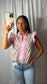 A women wearing a pink and lavender striped floral ruffle neck and sleeve top
