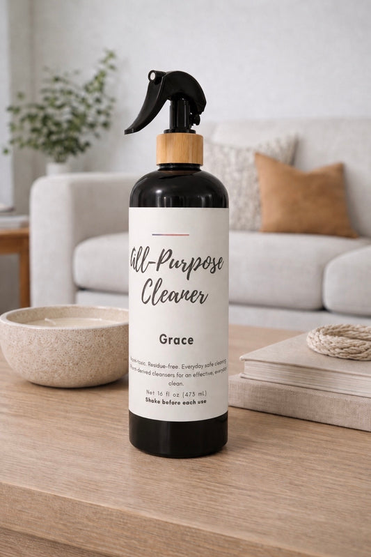 Bottle of all-purpose cleaner labeled 'Grace' on a wooden surface with a living room background.