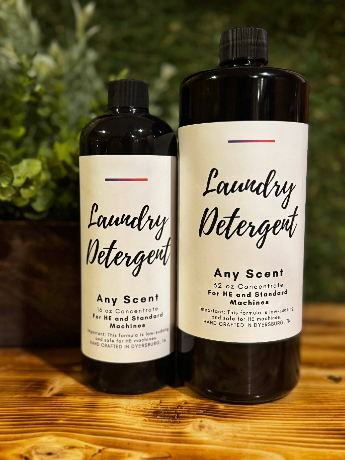 Two bottles of laundry detergent on a wooden surface with a greenery background
