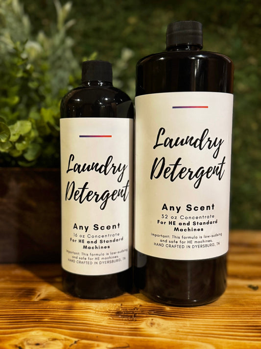 Two bottles of laundry detergent on a wooden surface with a greenery background