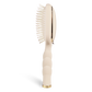 Tan hairbrush with gold accents on a white background