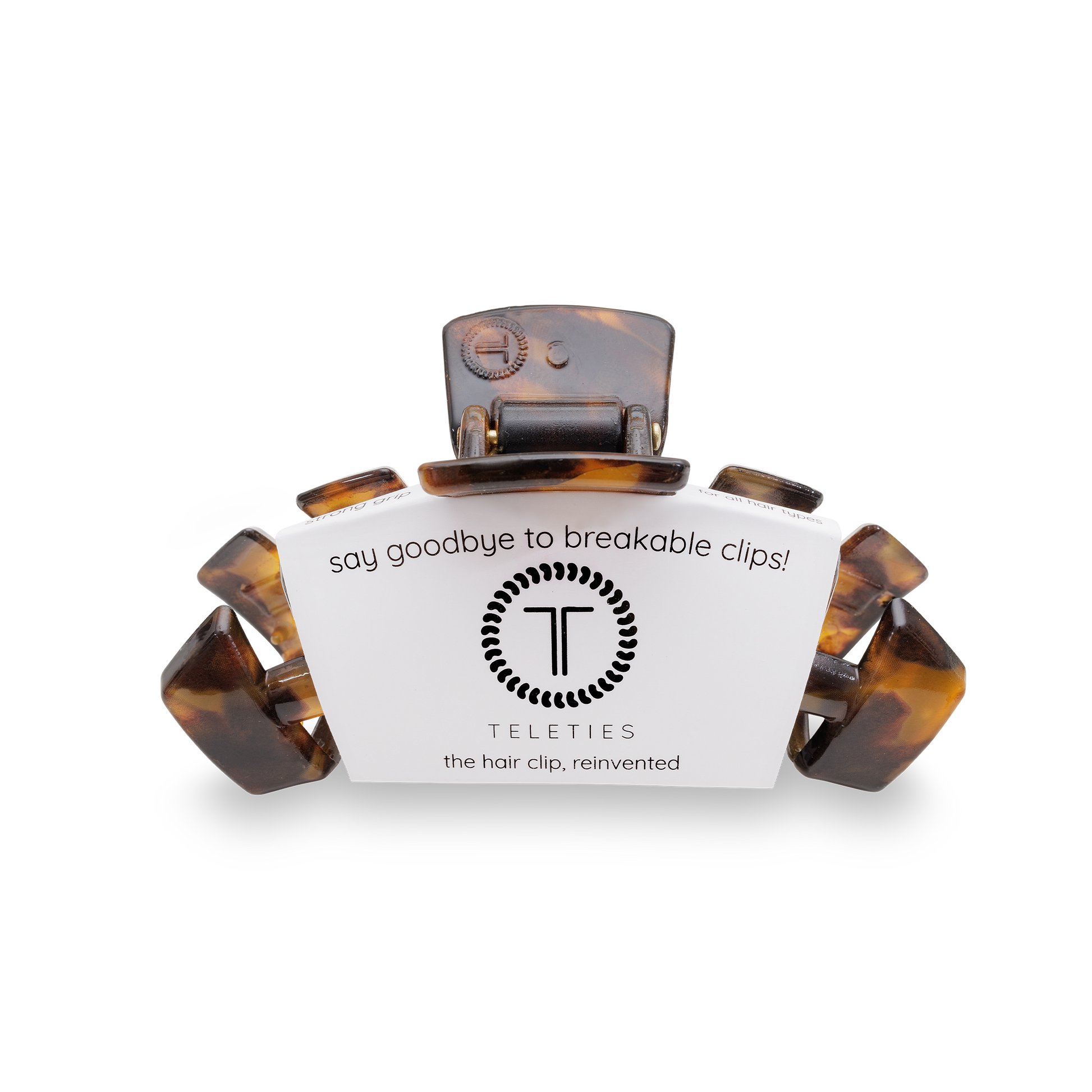 Tortoiseshell hair clip with a label teleties on a white background