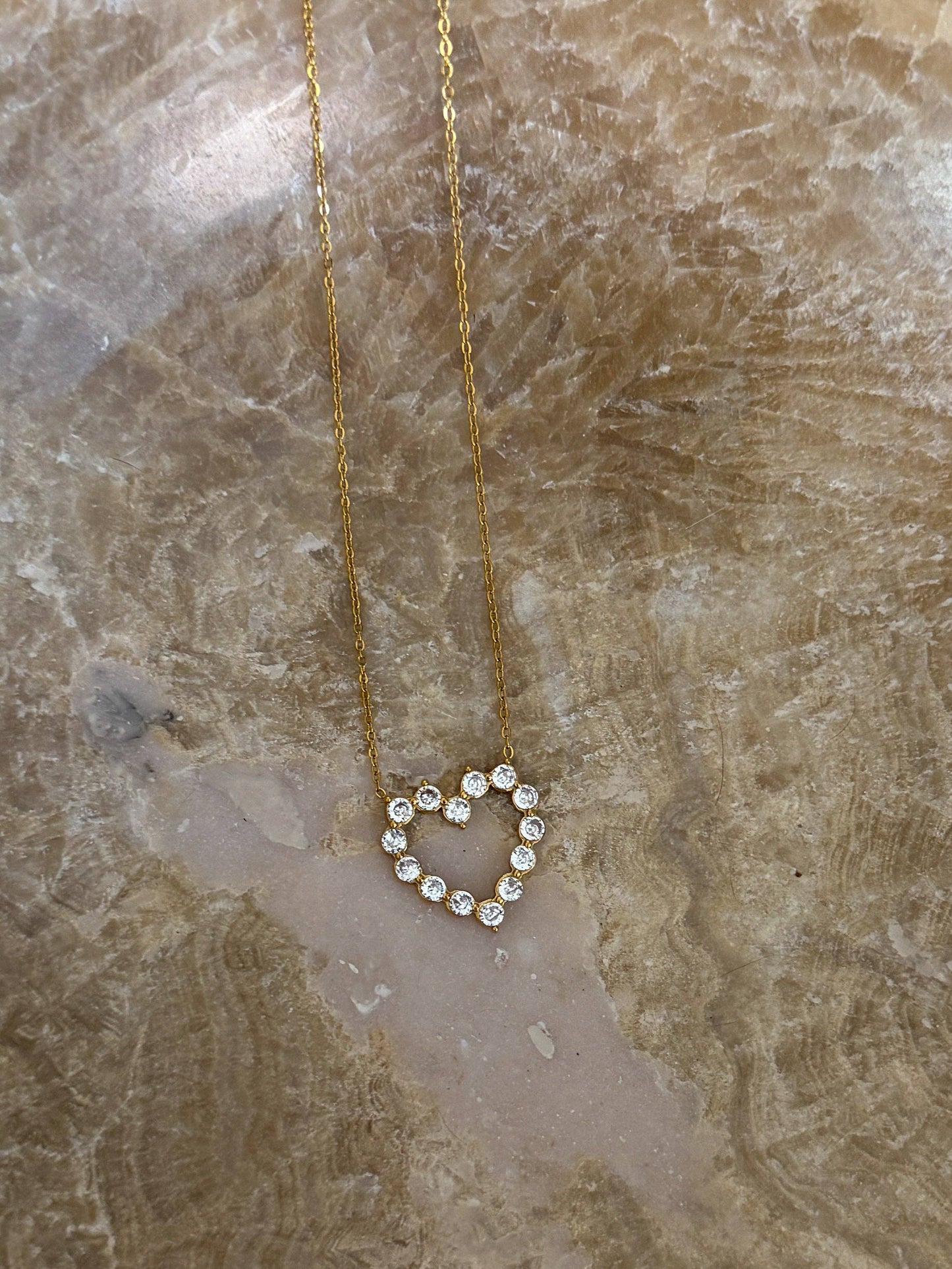 Gold heart pendant necklace with crystal accents on a delicate chain