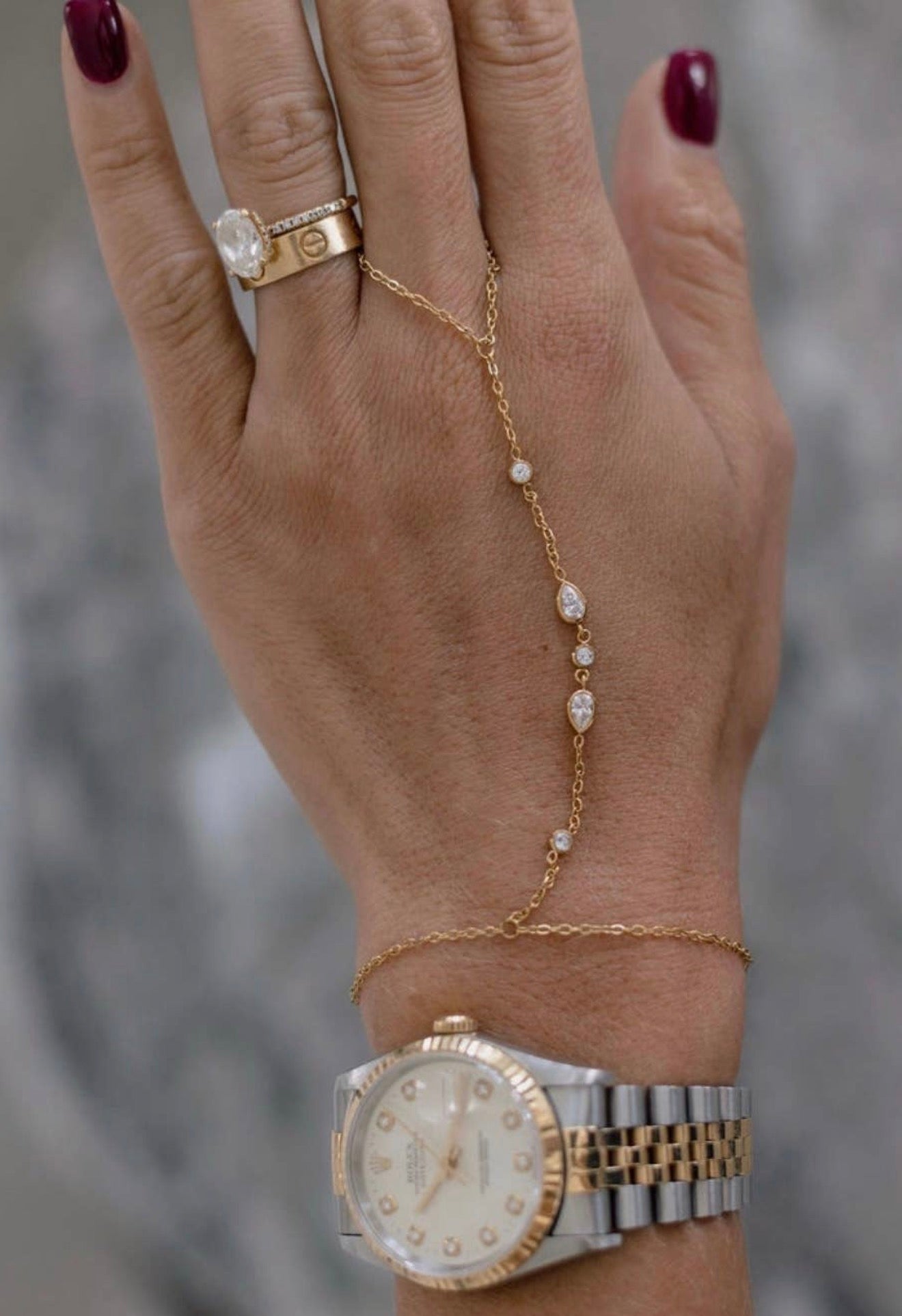 Delicate gold hand chain bracelet with gold accent diamonds