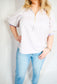 Woman wearing a striped shirt and light blue jeans against a white background
