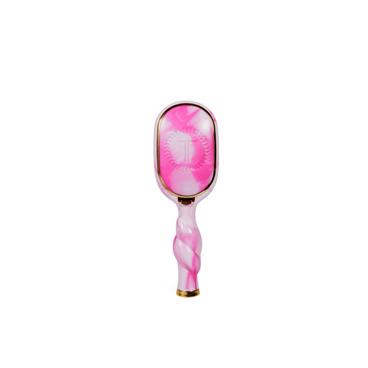 Pink and white hairbrush with gold accents on a white background