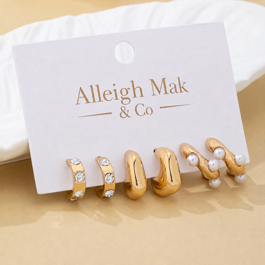 Set of gold and pearl earrings on a branded card with 'Alleigh Mak & Co' on a beige background