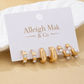 Set of gold and pearl earrings on a branded card with 'Alleigh Mak & Co' on a beige background