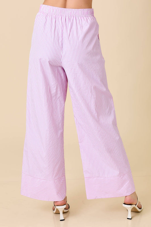 Pink striped pants worn by a person on a beige background